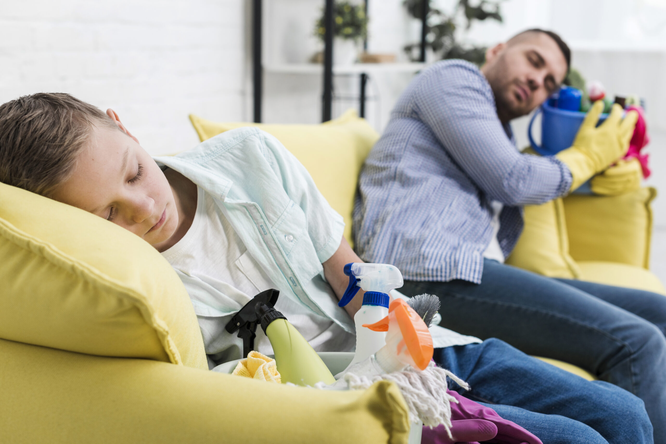 sleepy-father-son-resting-sofa-after-cleaning